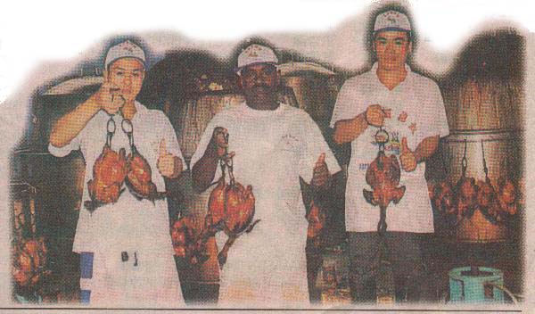 Workers showing off the delicious roasted chickens